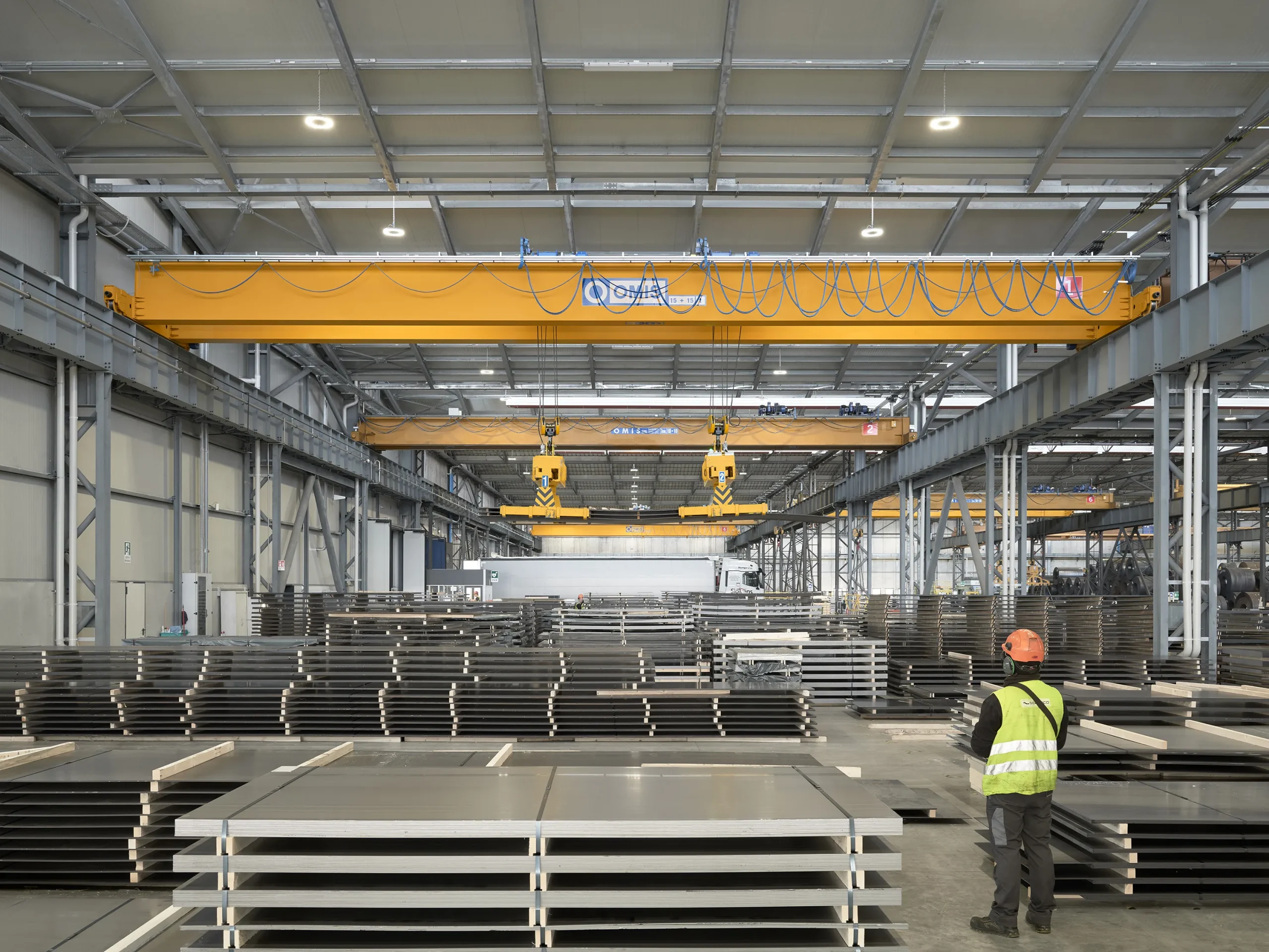 gallery - Double-girder overhead crane 15t double lifting steel industry operator lifting handling sheet metal packs sidastico front Omis